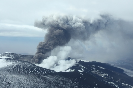 black ash covering ice under ash plume